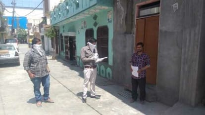 डोर टू डोर सर्वे करते कर्मचारी।